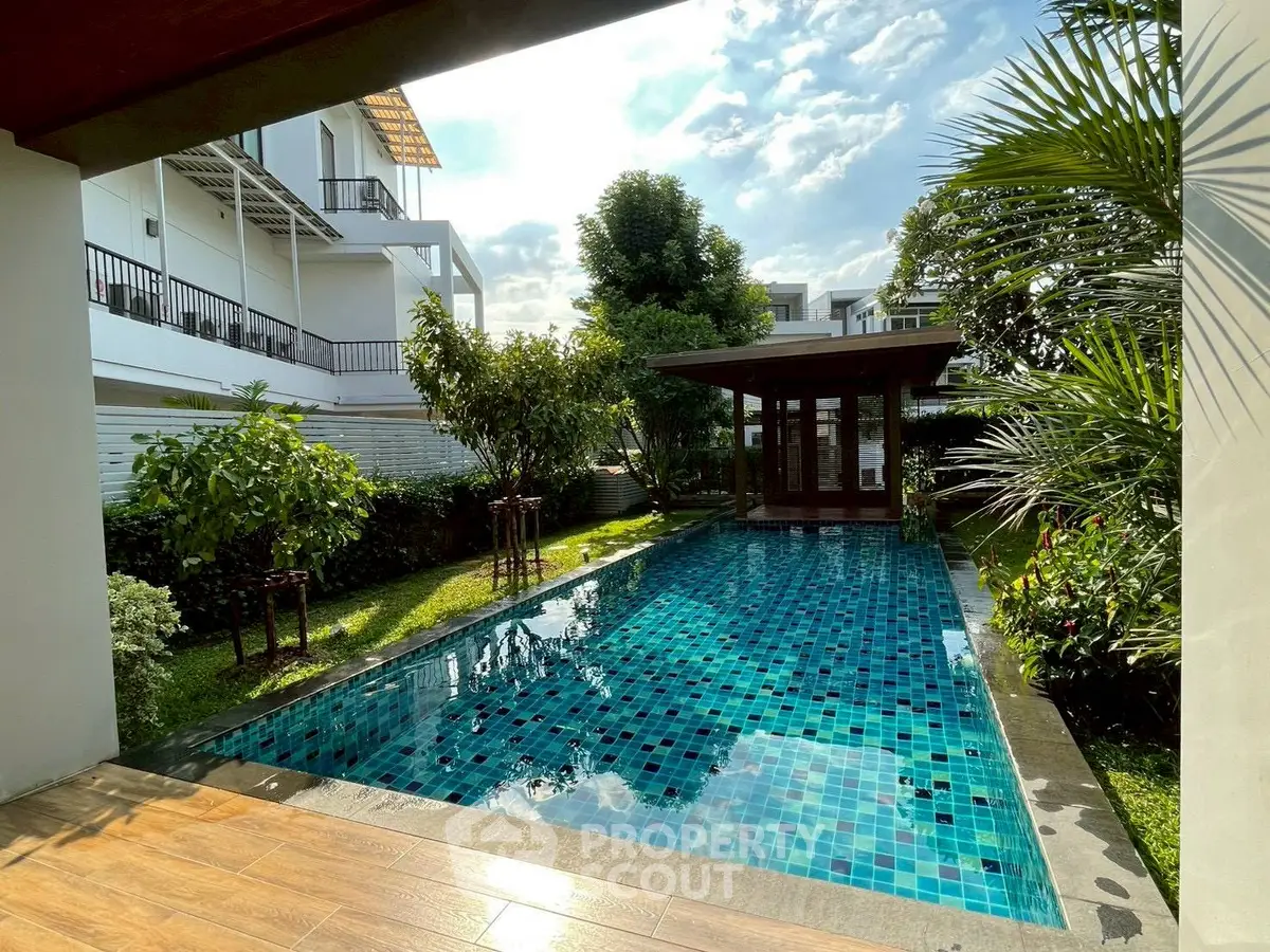 Luxurious private pool surrounded by lush greenery in a modern residential property.