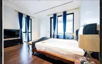 Luxurious bedroom with elegant decor, hardwood floors, and large windows for natural light.