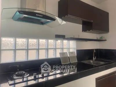 Modern kitchen with sleek black countertops and built-in gas stove