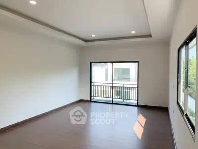 Spacious empty room with large windows and balcony access in modern apartment