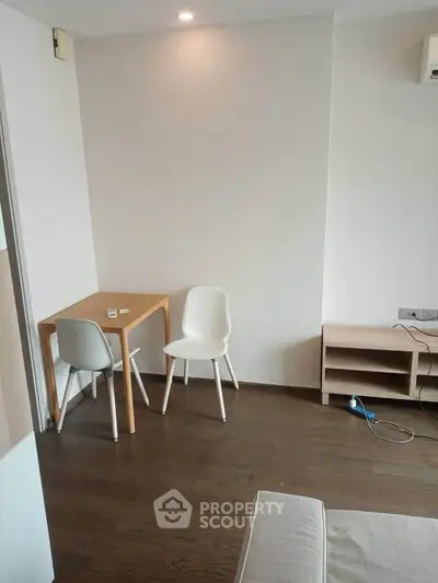 Cozy minimalist living space with wooden flooring and modern furniture, perfect for urban living.