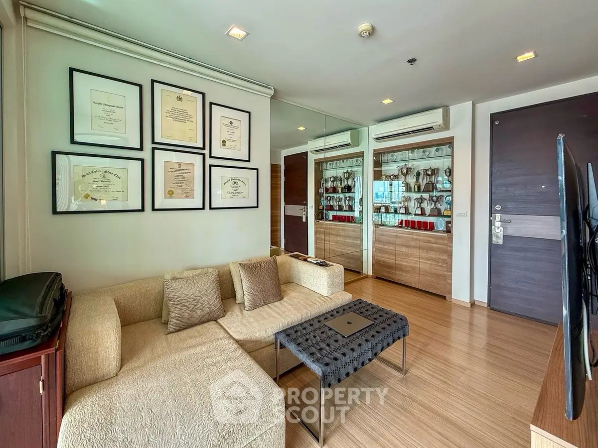 Modern living room with elegant decor and wall-mounted certificates