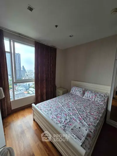 Cozy bedroom with floral bedding and city view from large window