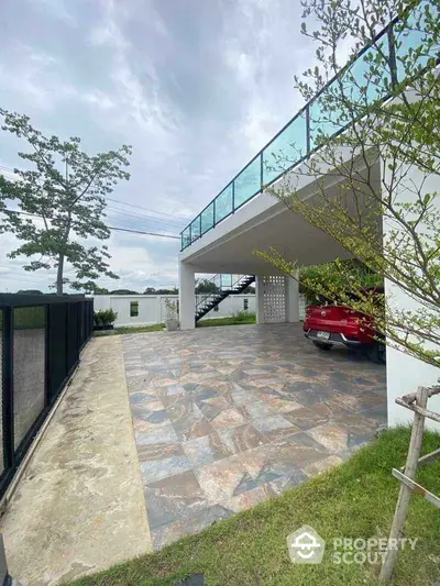 Modern home with elevated parking and sleek glass railings