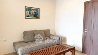 Cozy living room with modern gray sofa and wooden coffee table, featuring elegant wall art.