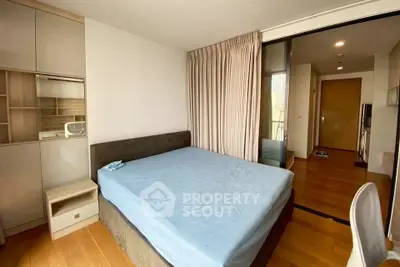 Spacious bedroom with modern furnishings and wooden flooring in a stylish apartment.