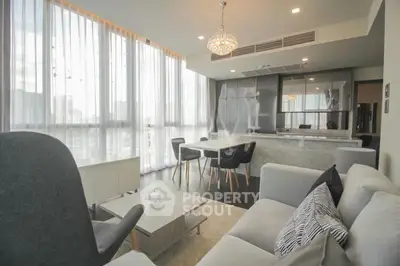 Luxurious modern living room with elegant decor and large windows offering city views.