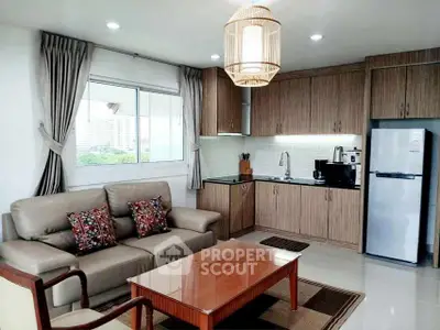 Modern kitchen and living room with stylish decor and natural light.