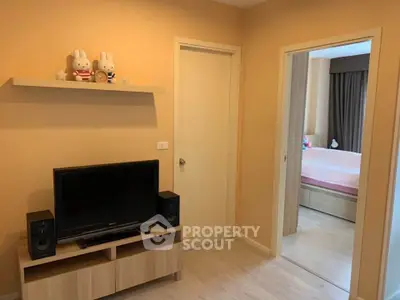 Cozy living room with TV and bedroom view in modern apartment