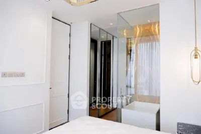 Luxurious modern bedroom with glass-enclosed bathtub and elegant lighting