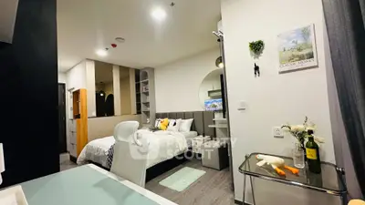 Modern bedroom with stylish decor and workspace in a cozy apartment.