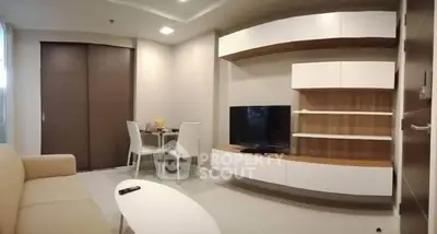 Modern living room with sleek furniture and TV unit in a cozy apartment.