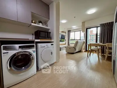 Modern open-plan living room with washing machine and dryer, bright and spacious.