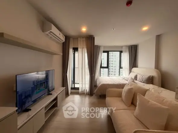 Modern studio apartment with cozy living area and large windows
