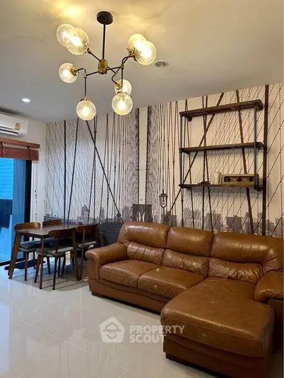 Stylish living room with leather sofa and modern lighting, perfect for relaxation and entertaining.