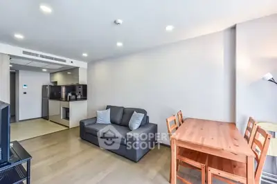 Modern living room with cozy sofa and dining area in open layout apartment.