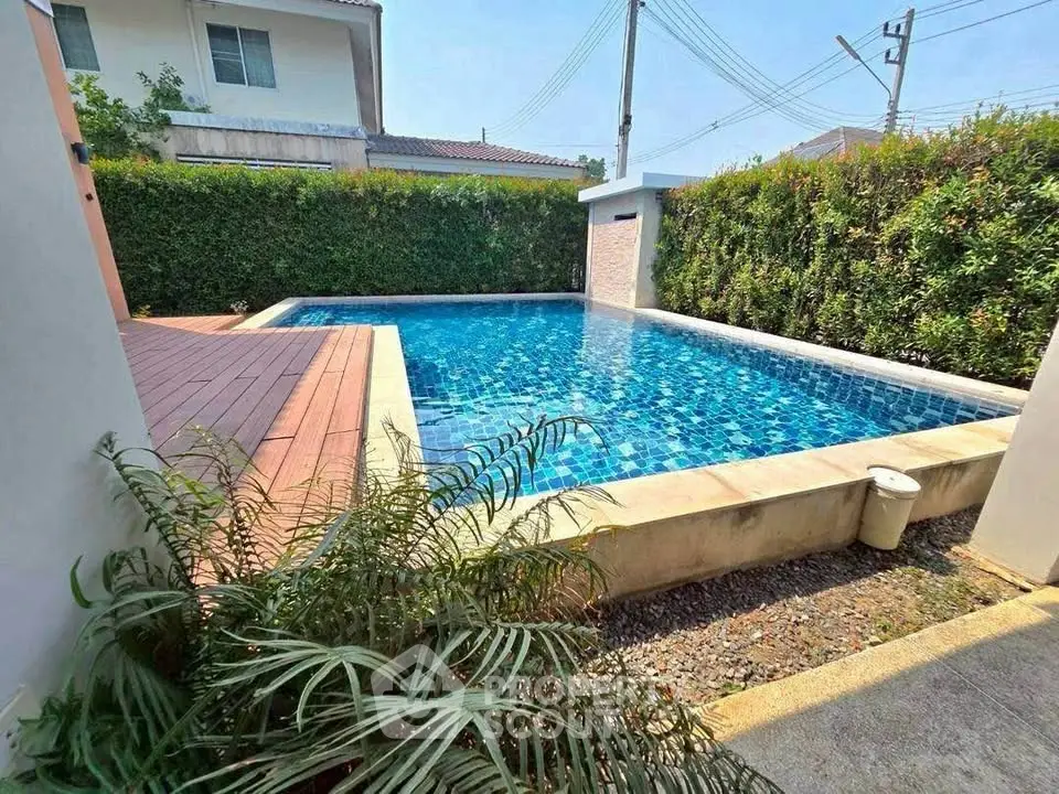 Charming private pool with lush greenery in a serene residential setting.