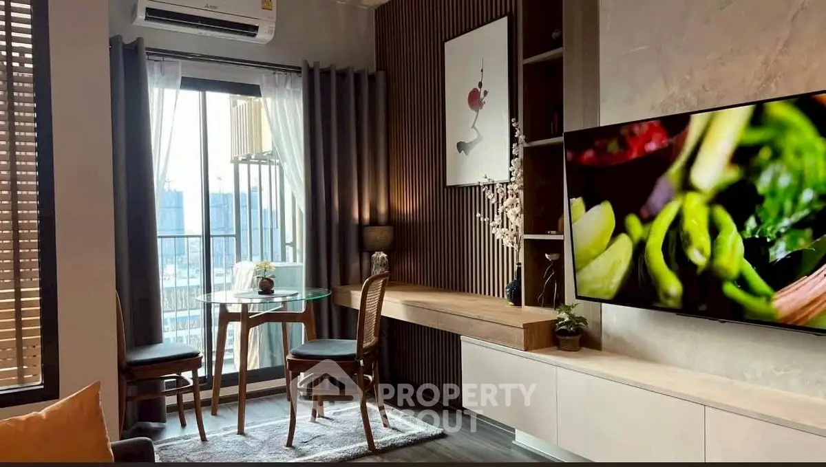 Modern living room with large TV, stylish decor, and city view from window.
