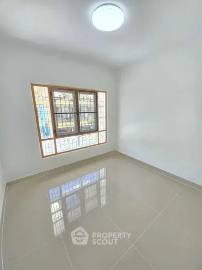 Bright empty room with large window and glossy tiled floor, perfect for customization.