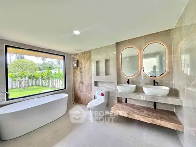 Luxurious modern bathroom with dual sinks and garden view