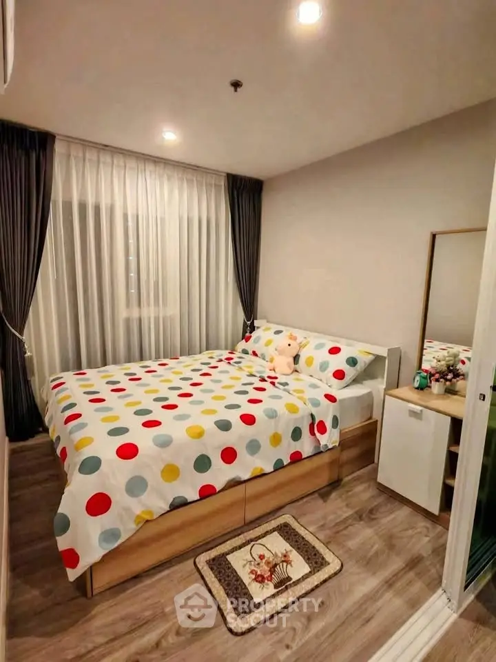 Cozy bedroom with colorful polka dot bedding and elegant curtains, perfect for a restful retreat.