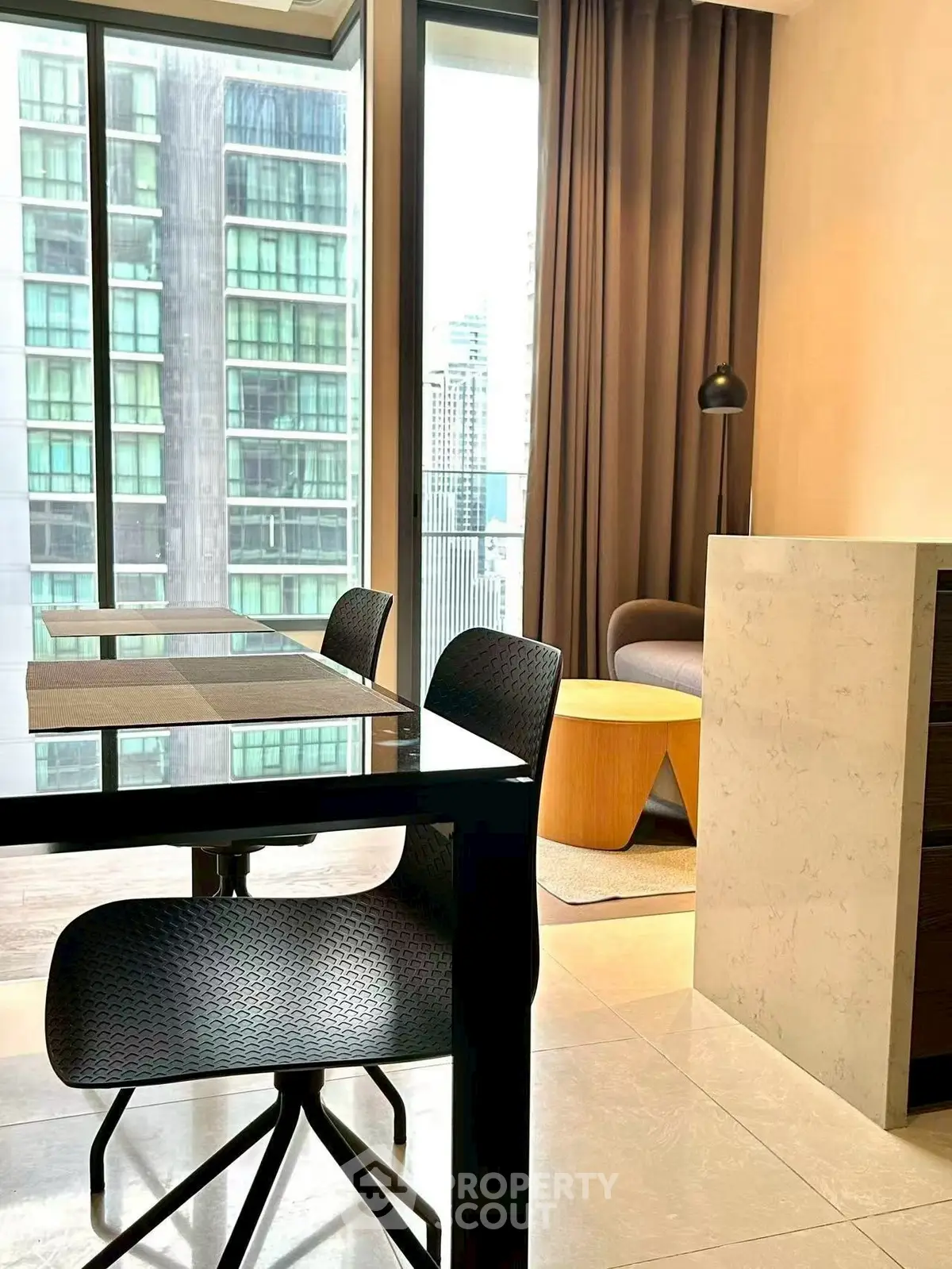 Modern dining area with city view, sleek furniture, and floor-to-ceiling windows.