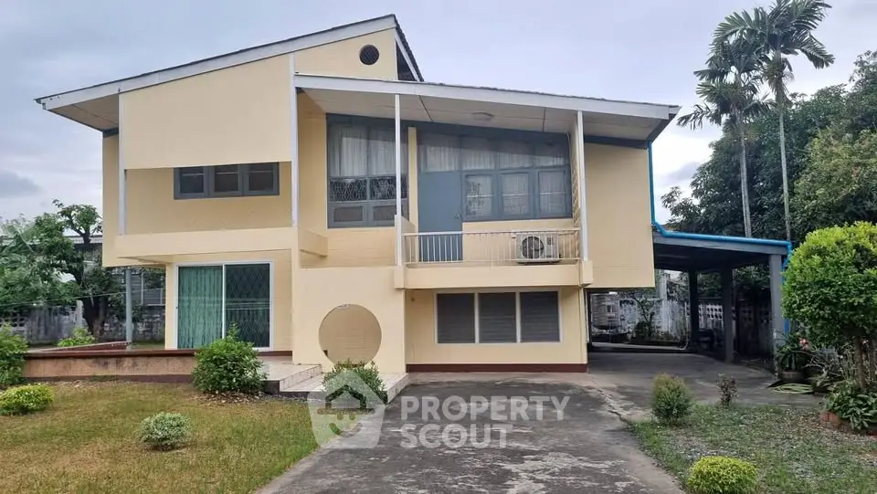 Charming two-story house with spacious driveway and lush greenery, perfect for family living.