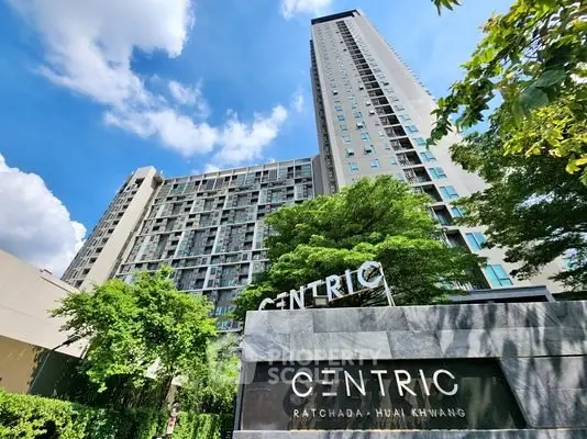 Modern high-rise building with lush greenery at Centric Ratchada-Huai Khwang.