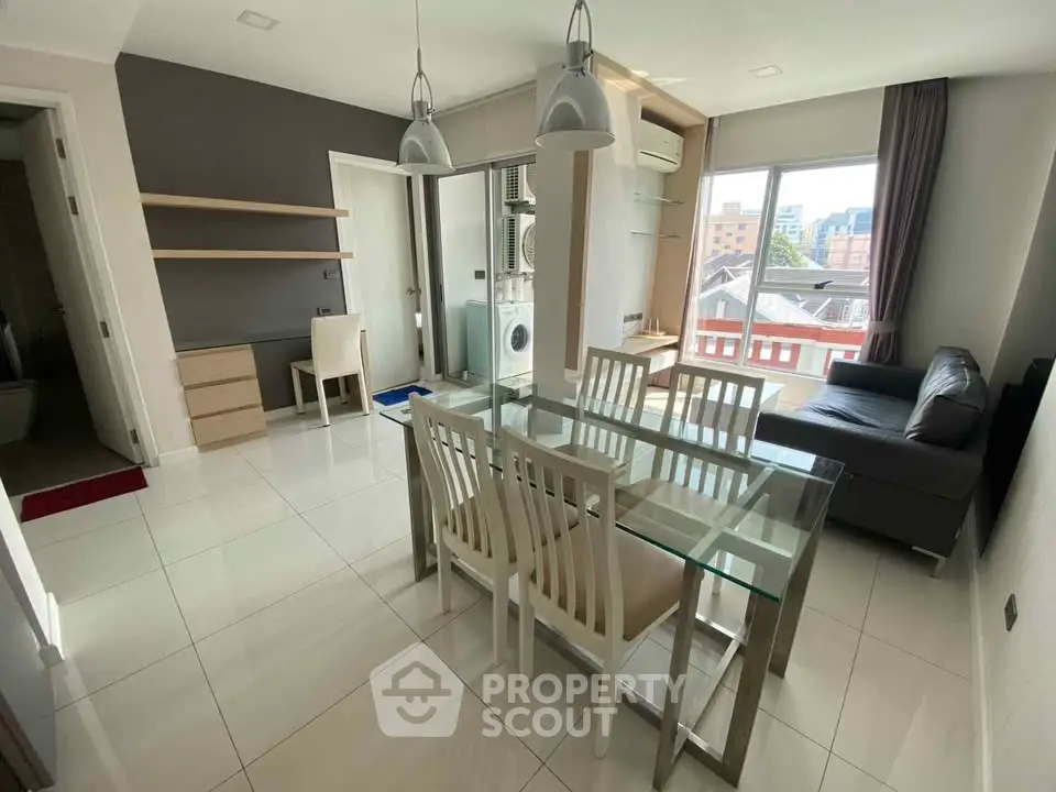 Modern dining area with glass table and city view in stylish apartment