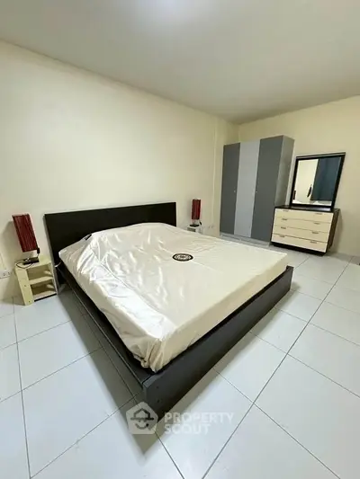 Spacious bedroom with modern furniture and ample storage space