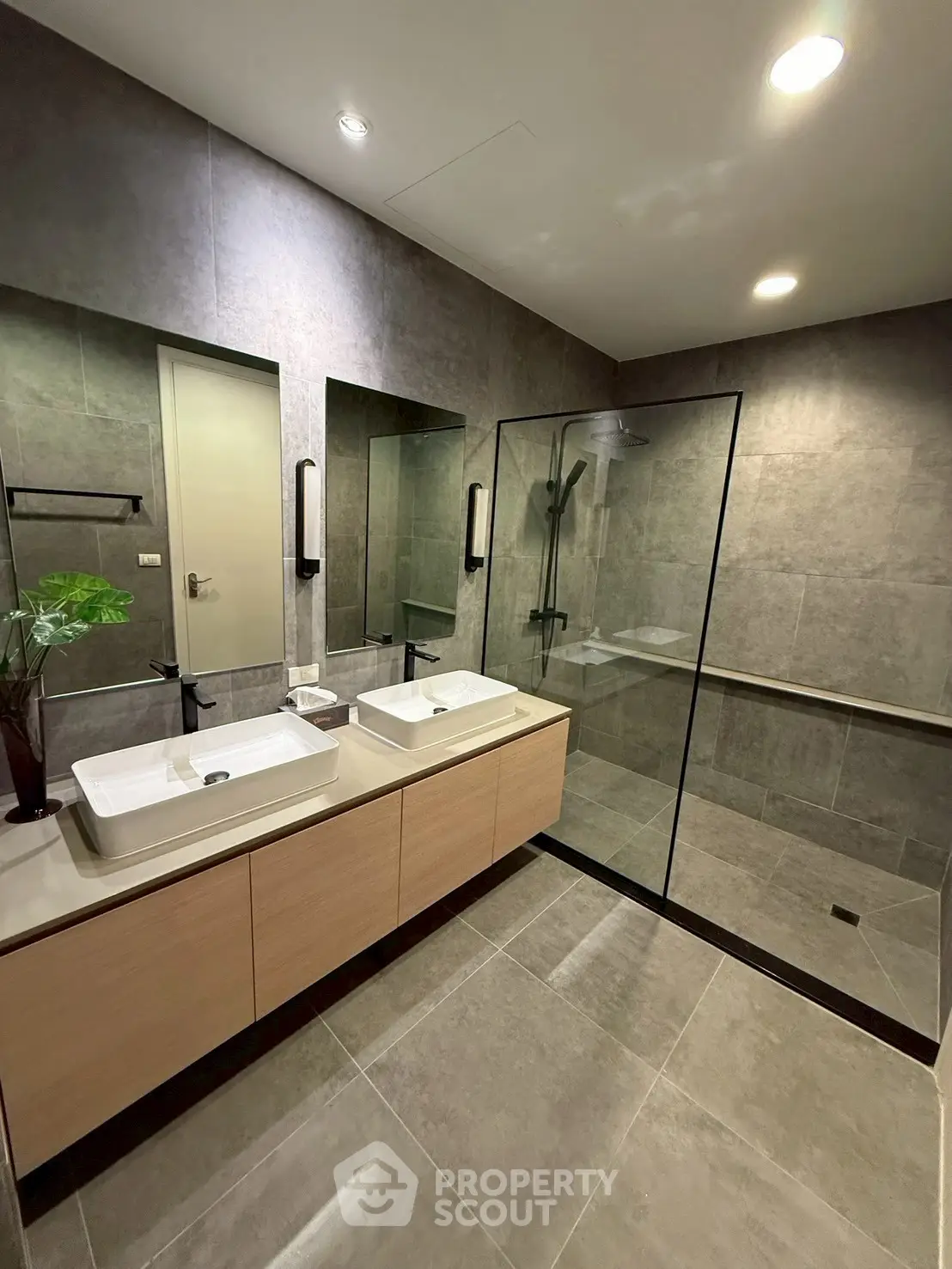 Modern bathroom with dual sinks and glass shower enclosure