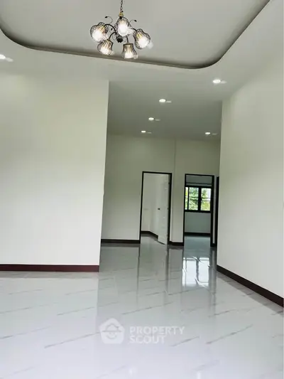 Spacious modern living room with elegant lighting and glossy tiled floors