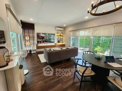 Spacious modern living room with elegant decor and large windows overlooking a lush garden.