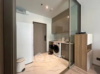 Modern kitchen with sleek appliances and stylish cabinetry in a contemporary apartment.