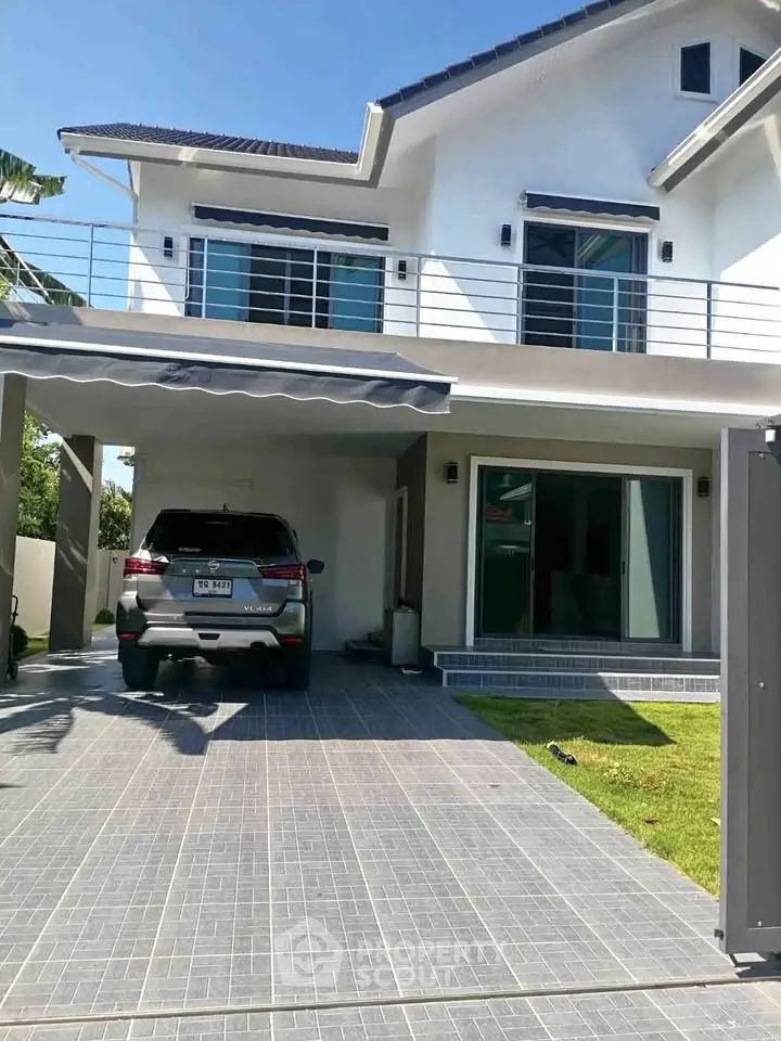 Modern two-story house with carport and spacious driveway in a serene neighborhood.