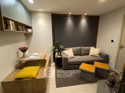 Modern living room with cozy sofa and stylish decor in a compact space.