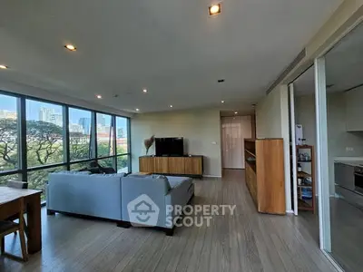 Spacious living room with large windows offering stunning city views and modern furnishings.
