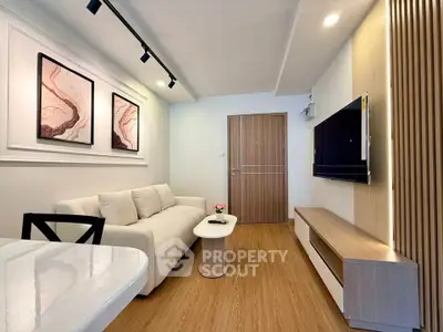 Modern living room with stylish decor, cozy sofa, and wall-mounted TV in a contemporary apartment.