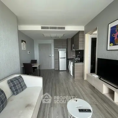 Modern living room with open kitchen, stylish decor, and natural light