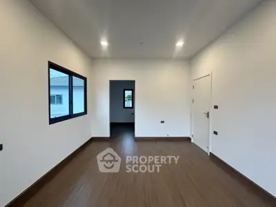 Spacious modern room with wooden flooring and large windows