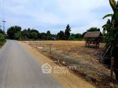 Expansive land plot with road access and lush greenery, ideal for development or agriculture.