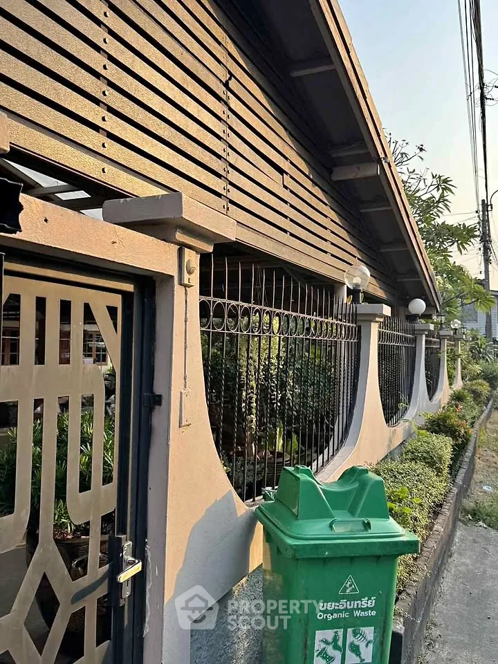 Charming residential exterior with unique architectural design and lush greenery, perfect for serene living.