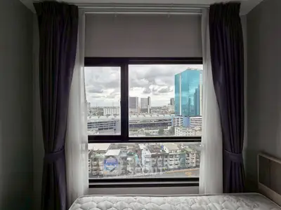 Stunning cityscape view from a modern bedroom window with elegant curtains.