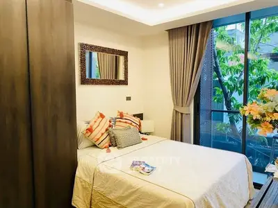 Cozy bedroom with elegant decor and large window overlooking lush greenery, perfect for relaxation.