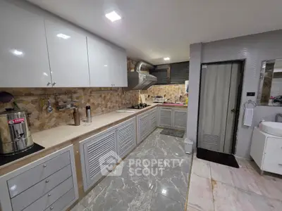 Modern kitchen with sleek cabinets and marble flooring