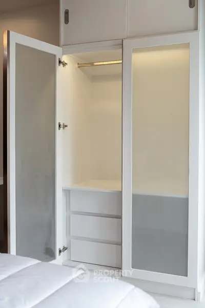 Spacious white wardrobe with mirrored doors in modern bedroom