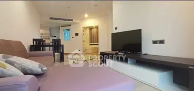 Modern living room with sleek furniture and flat-screen TV in a cozy apartment setting.