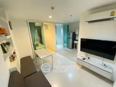 Modern living room with sleek furniture and open kitchen in a stylish apartment.