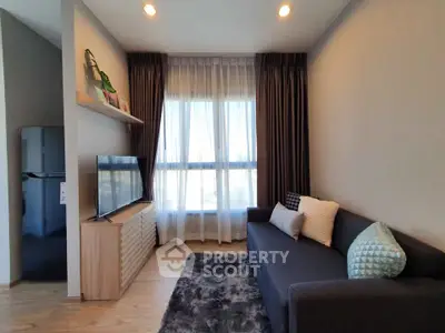 Modern living room with sleek furniture and large window, perfect for cozy relaxation.