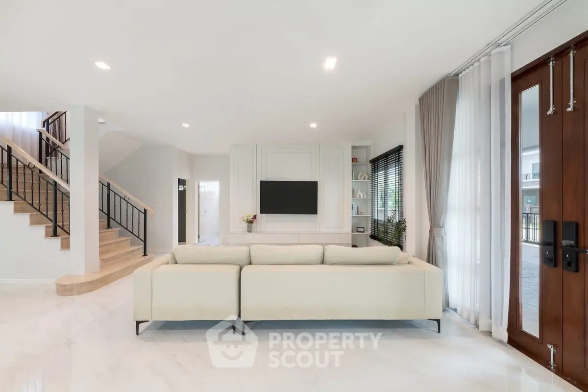 Spacious modern living room with elegant staircase and natural light